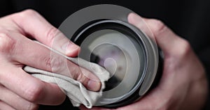 man wipe camera lens with microfiber close-up