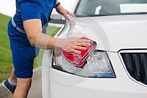 man wipes the car from dust and water