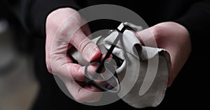 man wiping eyeglasses with a soft cloth close-up of hands