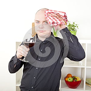 Man wiping his brow with a dishcloth