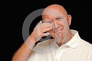 Man wiping tear from eye