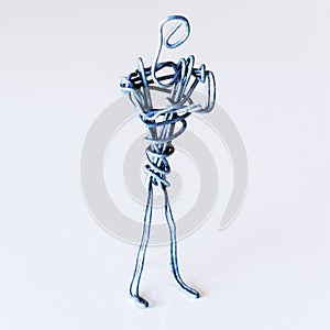 A man of wire stands in a closed position with his hands on his chest, symbolizing failure, aggression, closeness