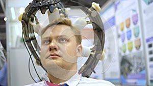 Man wired to an EEG machine or electroencephalograph which produces a graphical record of electrical activity of the