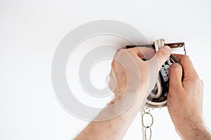 Man wiring ceiling light on white background