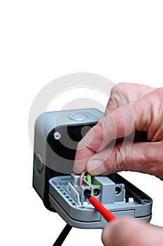 Man wiring an outdoor electric socket using an electrical screwdriver. Isolated on white background