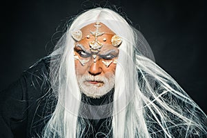 Man wizard with fantastic make up on demon face. Horror and fantasy concept. Ancient alchemy. I got power in spell. Tree