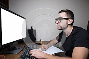 Man woking at PC on white screen monitor and make notice