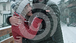 Man and woman aging youthfully enjoying snowing day in winter holiday vacation together with love and emotion. Excited couple have