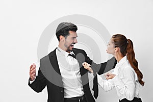 Man and woman anger business hitting on each other screaming with their hands up in the air on a white isolated