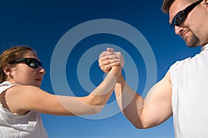 Man and Woman Arm Wrestling Outdoors
