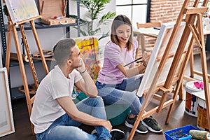 Man and woman artists couple smiling confident drawing at art studio