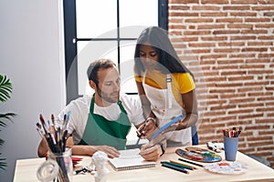Man and woman artists drawing on notebook using touchpad at art studio