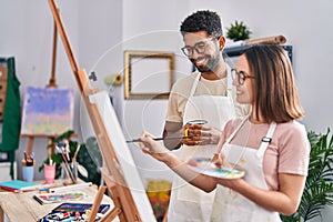 Man and woman artists drinking coffee drawing at art studio