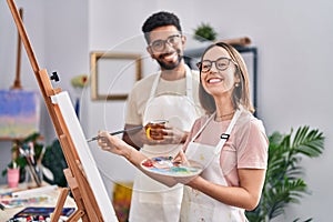 Man and woman artists drinking coffee drawing at art studio