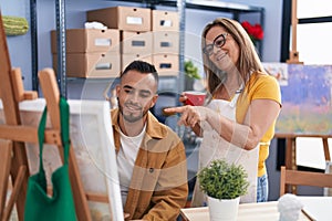 Man and woman artists drinking coffee drawing at art studio