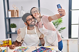 Man and woman artists make selfie by smartphone drawing on notebook at art studio