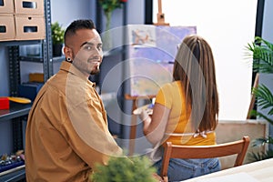 Man and woman artists smiling confident drawing at art studio