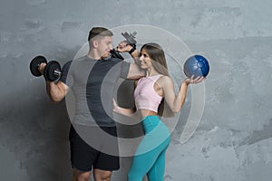 Man and woman athletes training with dumbbells and medicine ball. Personal trainings concept