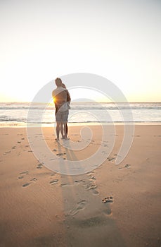 Man, woman and beach love at sunset for romantic summer travel or adventure, bonding or marriage. Couple, footprints and