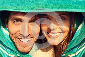 Man, woman and beach towel for protection or portrait together for weekend, bonding or embrace. Happy couple, face and