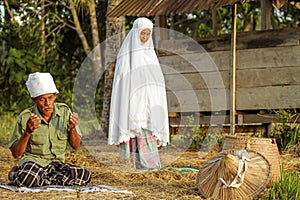 A man and woman behind him pray and salat