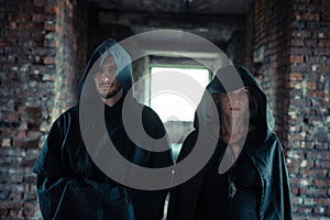 a man and a woman in black raincoats