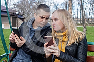 Man and a woman are both sitting on a date and sipping into their smartphones. Concept of social media addiction, getting out of