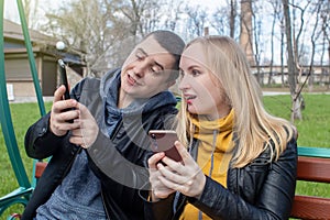 Man and a woman are both sitting on a date and sipping into their smartphones. Concept of social media addiction, getting out of