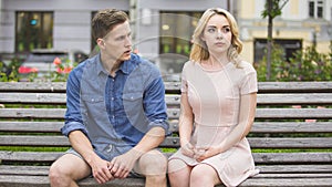 Man and woman breaking up on bench in park, conflict in relationship, problem