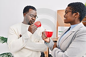 Man and woman business workers drinking coffee at office