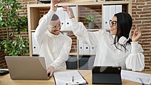 Man and woman business workers working together high five at office