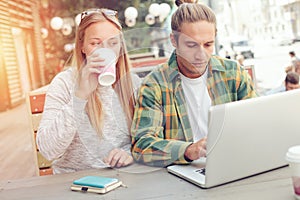 Man and woman in cafe working with laptop, coffee break