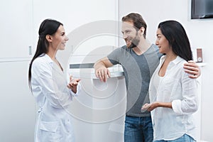 A man and a woman came to see a dentist. The receptionist fills in the form and interviews the patients.