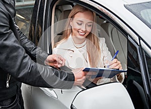 Man and woman at car dealership buying new car