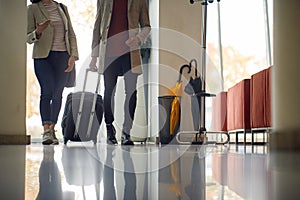 Man and woman carrying luggage in the lobby of a hotel.Business people with luggage