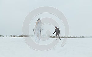 Man and woman in casual clothes having fun in nature on a frozen snowy lake