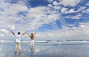 Man and Woman Celebrating Arms Raised On A Beach