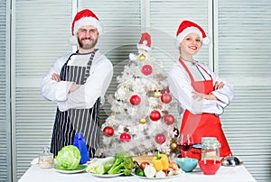 Man and woman chef apron santa hat near christmas tree. Christmas recipe concept. Cooking christmas meal. Secret