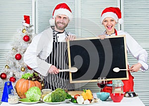 Man and woman chef santa hat near christmas tree hold blackboard copy space. Family traditional menu for christmas