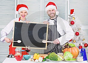 Man and woman chef santa hat near christmas tree hold blackboard copy space. Family traditional menu for christmas
