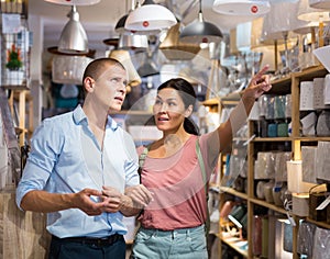 Man and woman choosing lamps in store photo