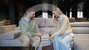 Man and woman choosing upholstery materials for sofa in furniture store