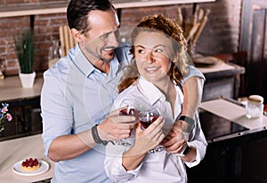 Man and woman clanging glasses together