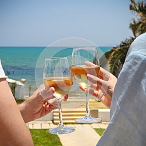 Man and woman clanging wine glasses with white wine