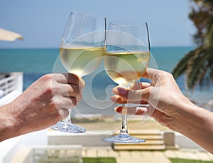 Man and woman clanging wine glasses with white wine