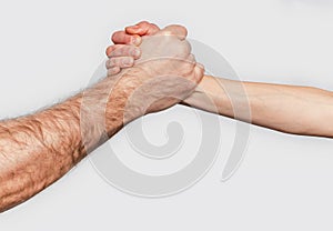 Man and woman with clasped hands engage in arm wrestling. Gray background. Struggle man and woman