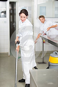 Man and woman cleaning floor in profesional kitchen