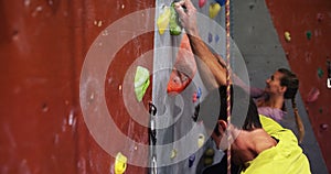 Man and woman climbing the artificial wall 4k