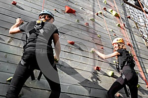 Man and woman climbing the wall in the park