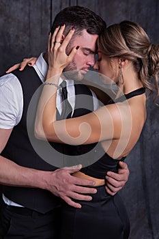 A man and a woman closing their eyes with pleasure tenderly embrace each other